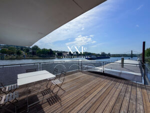 Terrasse d'une péniche d'habitation à Triel-sur-Seine avec vue dégagée sur la Seine, jardin privatif et environnement verdoyant